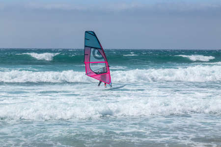 summer sports: a surfer riding the wave during a sunny day on the blue ocean sea of Guincho, Portugal.のeditorial素材