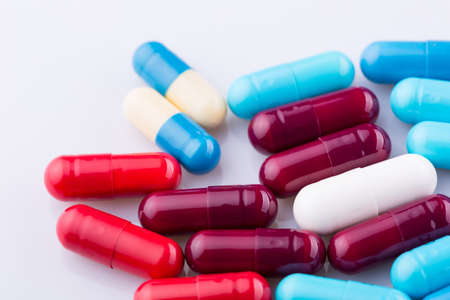 Tablets pills capsule heap mix therapy drugs, over a white backgroundの写真素材