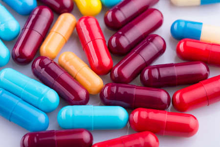 Tablets pills capsule heap mix therapy drugs, over a white backgroundの写真素材