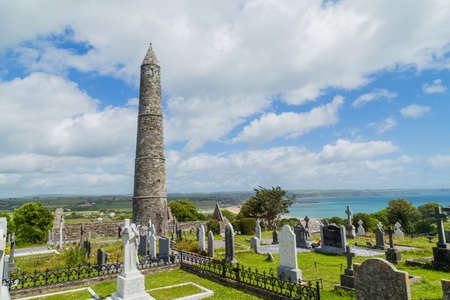 Stone round tower and some ruins of a monastic settlement originally built in the 6th century in Glendalough valley, County Wicklow, Ireland.のeditorial素材