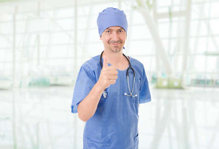 Happy male doctor showing thumbs up, at the hospitalの写真素材