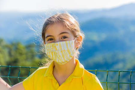 Little girl with mask against corona virus covid outdoorの写真素材