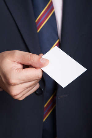 Business man holding a blank empty business card with isolated white screen. Businessman presenting his business cardの写真素材