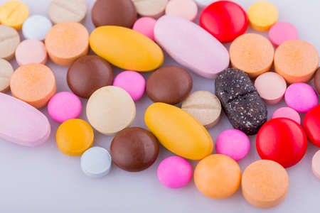 Tablets pills capsule heap mix therapy drugs, over a white backgroundの写真素材