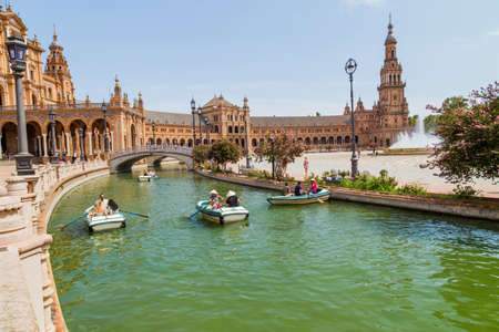 Seville, Andalusia, Spain: Central Renaissance building in Plaza de Espana square, view of Guadalquivir river with boats and people in the day time.のeditorial素材