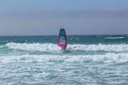 summer sports: a surfer riding the wave during a sunny day on the blue ocean sea of Guincho, Portugal.のeditorial素材