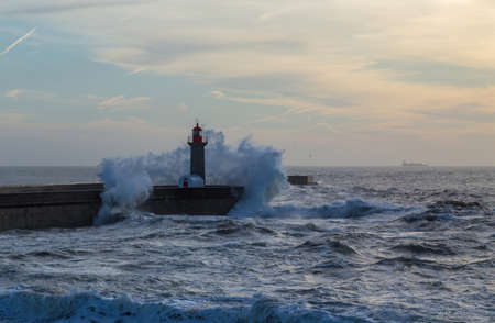 Foz Lighthouse during a storm at sunset in Atlantic ocean, Porto, Portugal.の写真素材