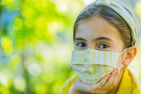 Little girl with mask against corona virus covid outdoorの写真素材