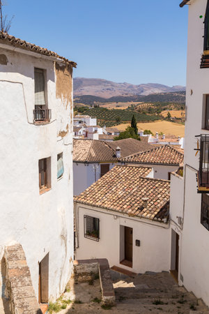 White houses in a historic narrow street of Ronda, Spainの写真素材