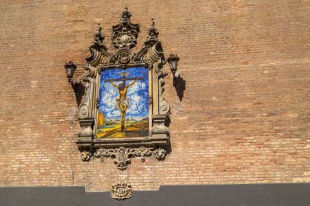 Azulejo showing Jesus on the cross on an external wall of the Church of the Annunciation (Iglesia de la Anunciacion) in Seville Spain. The church in Renaissance style was built in 1565 as house of the Society of Jesus.の写真素材