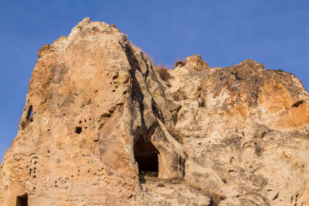 View of house carved in cave. Ruins of an ancient cave house. Historical rock dwellings. Cappadocia, Turkey.の写真素材