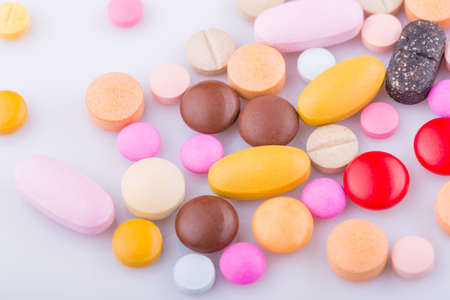 Tablets pills capsule heap mix therapy drugs, over a white backgroundの写真素材