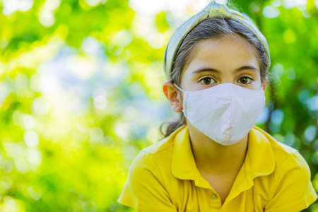 Little girl with mask against corona virus covid outdoorの写真素材