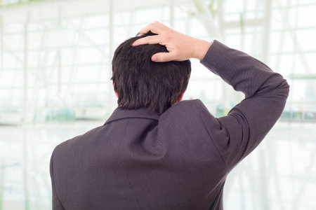 Back view of a worried businessman thinking, at the officeの写真素材