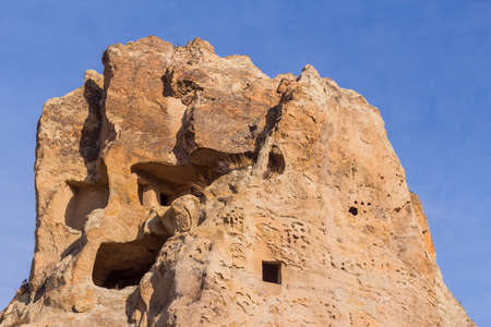 View of house carved in cave. Ruins of an ancient cave house. Historical rock dwellings. Cappadocia, Turkey.の写真素材