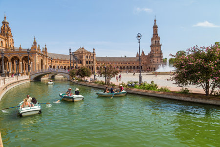 Seville, Andalusia, Spain: Central Renaissance building in Plaza de Espana square, view of Guadalquivir river with boats and people in the day time.のeditorial素材