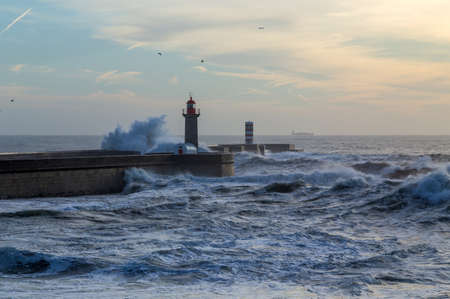 Foz Lighthouse during a storm at sunset in Atlantic ocean, Porto, Portugal.の写真素材