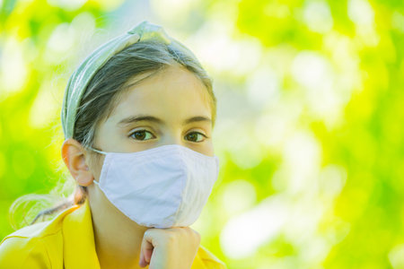 Little girl with mask against corona virus covid outdoorの写真素材