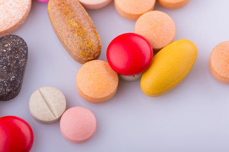 Tablets pills capsule heap mix therapy drugs, over a white backgroundの写真素材