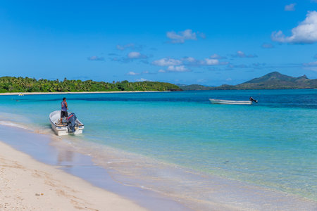 Nacula; Fiji: Man in a boat on the beach waiting for tourists, Yasawa Island group in Fijiのeditorial素材