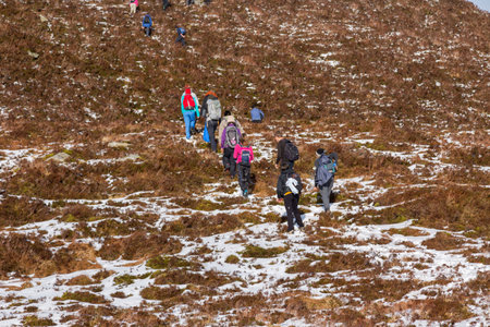 CO KERRY, IRLAND: People climbing in the snow at the Paps of Anu, Co Kerry, Irelandのeditorial素材