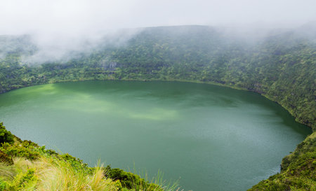 Deep lake in Flores Island, Azores Archipelago, Portugal. Green lagoon with green vegetationの写真素材