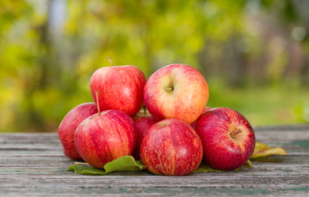 Close-up of few organic red apples on a wooden table.の写真素材