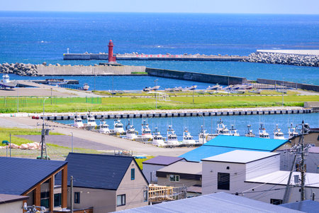 A coastal landscape of Cape Soya and Soya Port in northern Hokkaido, Japan, under the clear blue sky of June. The calm sea, distant hills, and fresh summer air capture the serene aの写真素材