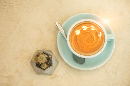 Coffee cup and a cactus on old rocky floor. Top view with copyspace for your text.の写真素材
