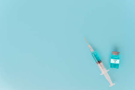 A syringe with liquid vaccines on blueの写真素材