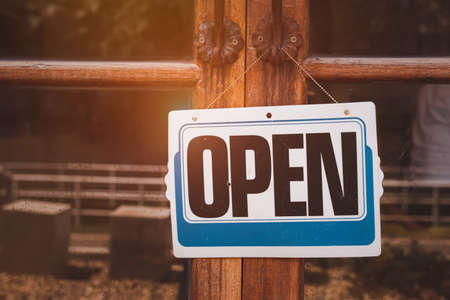 Text on white sign board  â open" was hung on the glassâs shop with the   vintage background. The glass was a bit dirty and dusty tone.の写真素材