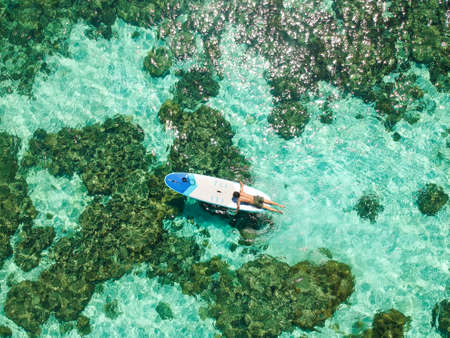 A man was doing paddleboard surfing on the surface of the water at Koh Lipe, Thailand.の写真素材