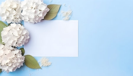 Invitation card mockup with empty paper blank decorated blue and pink hydrangea flowers on pastel light blue background top viewの素材