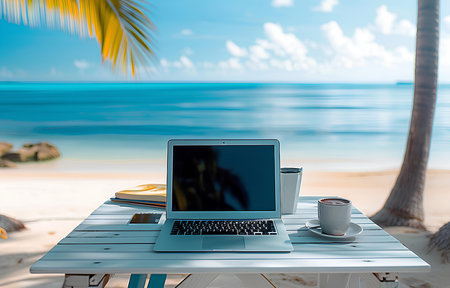 working place with silver laptop on white wooden table over beautiful summer tropic seaside backgroundの素材