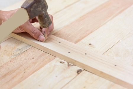Worker hammer the nail into the woodの写真素材