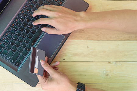use credit card for shopping online on laptop / holding the credit card or shopping online on laptop