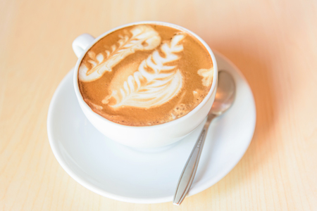 hot cappuccino coffee with nice pattern foam on tableの写真素材