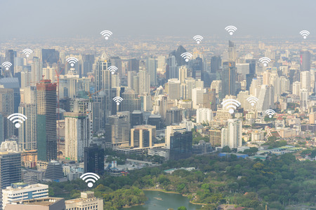 Cityscape of Bangkok with added generic wifi signals and access points and business man use...