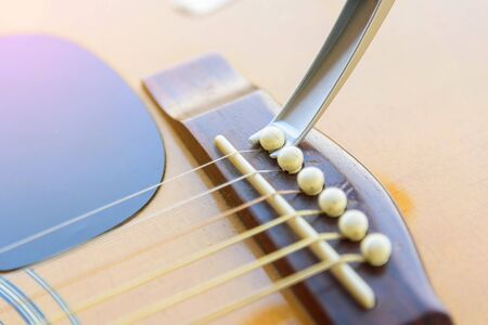 Remove acoustic guitar bridge pin by capo optionsの写真素材