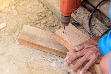 carpenter drill the wood by drill machineの写真素材