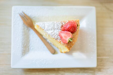 Top view of soft cake with stawberry and ice coffe on tableの写真素材