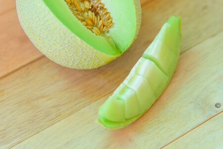 Fresh yeloow galia melon on wood plate