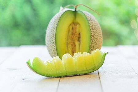 Fresh green melon on wood plate