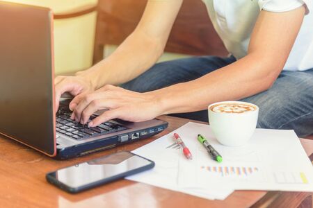 Work from home / The man use laptop and have a cup of hot coffee in working time