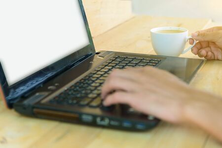 Work from home / The man use laptop and have a cup of hot coffee in working timeの写真素材