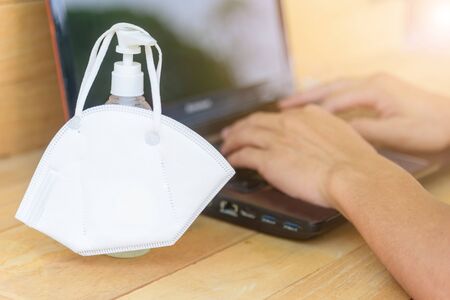 Work from home / The man wear N95 mask and use laptop for work from home in corona virus critical timeの写真素材