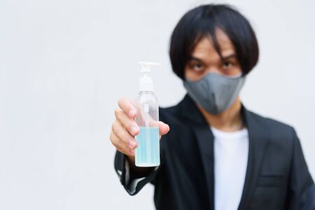 A asian man show alcohol gel item for protect from disease covid 19の写真素材