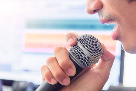 The man hold microphone for singing in studioの写真素材
