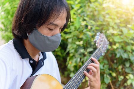 Guitarist playing guitar in the parkの写真素材