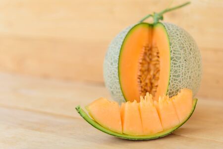 Fresh Orange melon on wood plateの写真素材